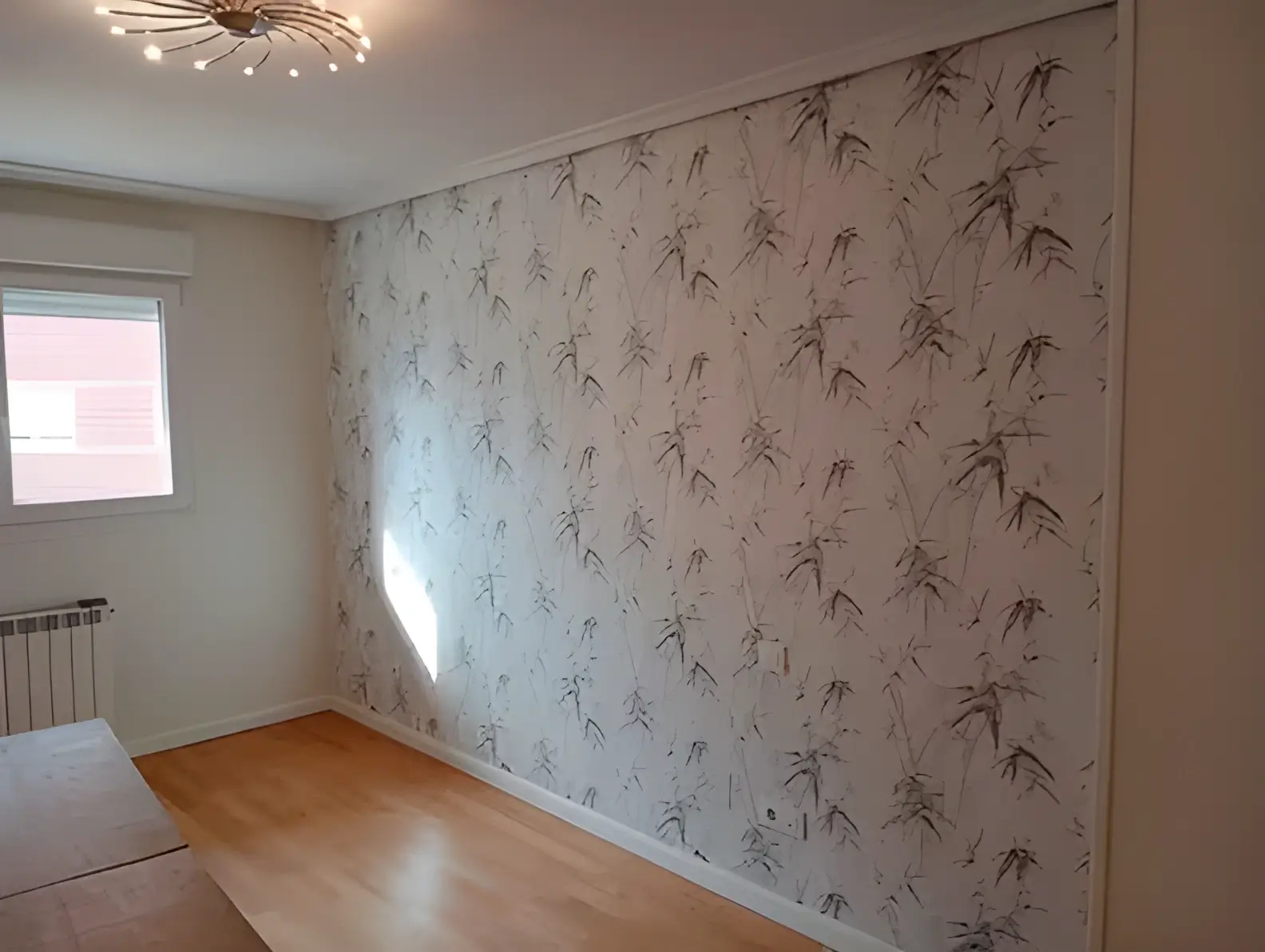 Los Pintores Ciudad Real colocando papel pintado en pared de acento de habitación luminosa