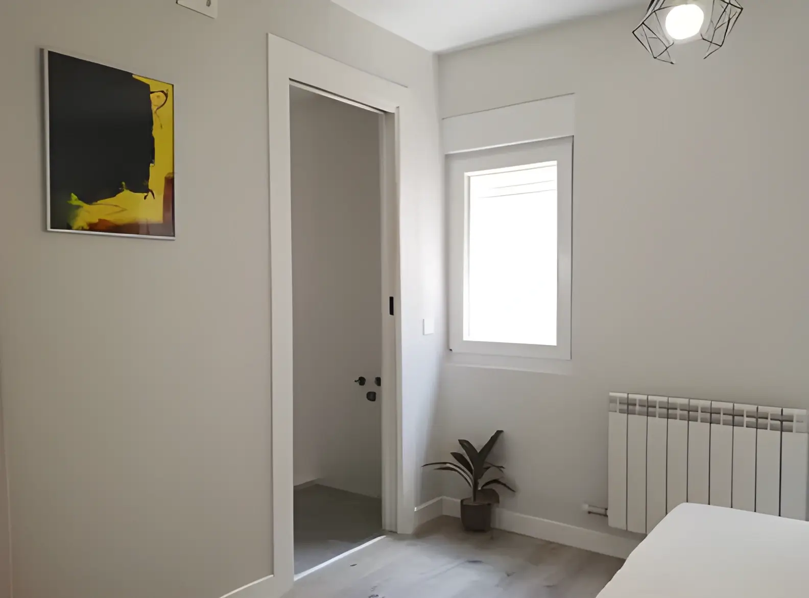 Habitación recién pintada en blanco por Los Pintores Ciudad Real para comunidad de vecinos